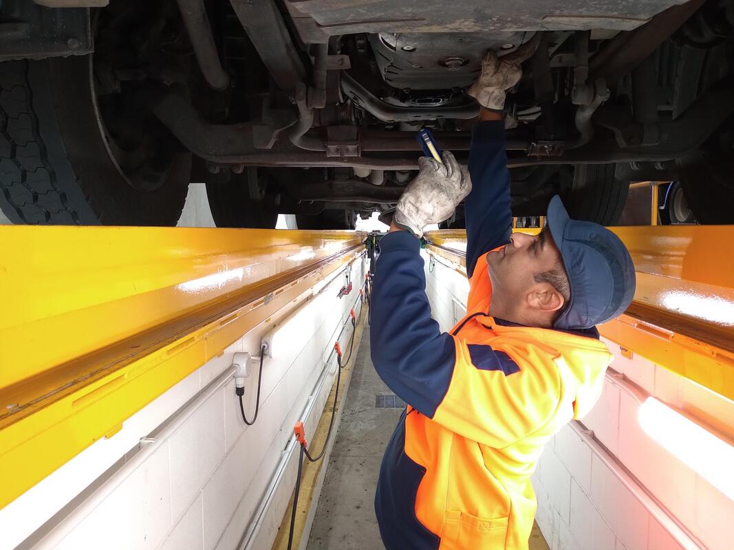 inspector examining underside of truck